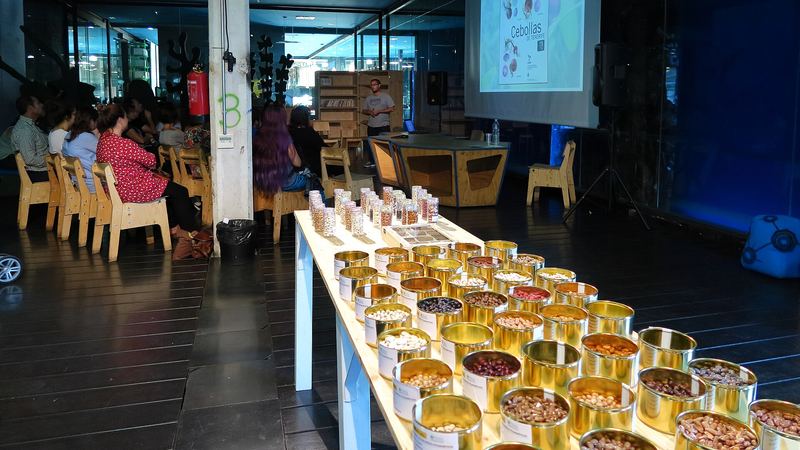 Latas con semillas expuestas en una mesa durante un encuentro de intercambio