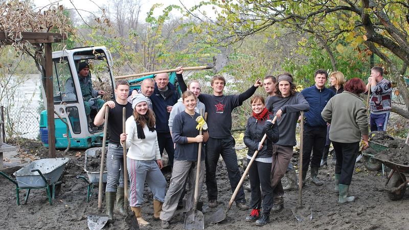 Grupo de voluntarios con palas y carretillas durante una jornada al aire libre